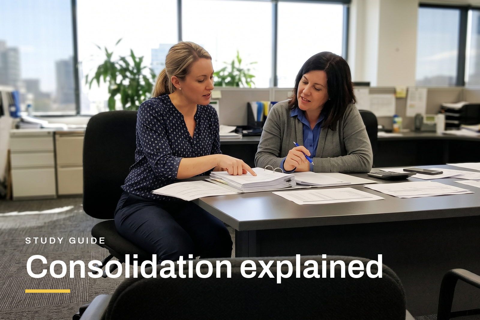 Consolidation explained header, two accountants working through a set of group accounts spread across a desk in an Australian office.