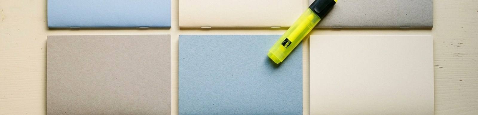 A grid of blank study booklets in muted blue, grey and cream with a yellow highlighter resting on top